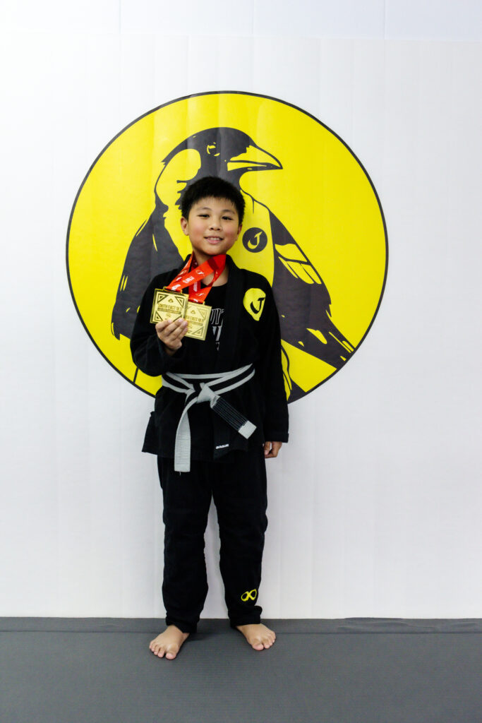 journey member standing with his medal at journey jiu jitsu.