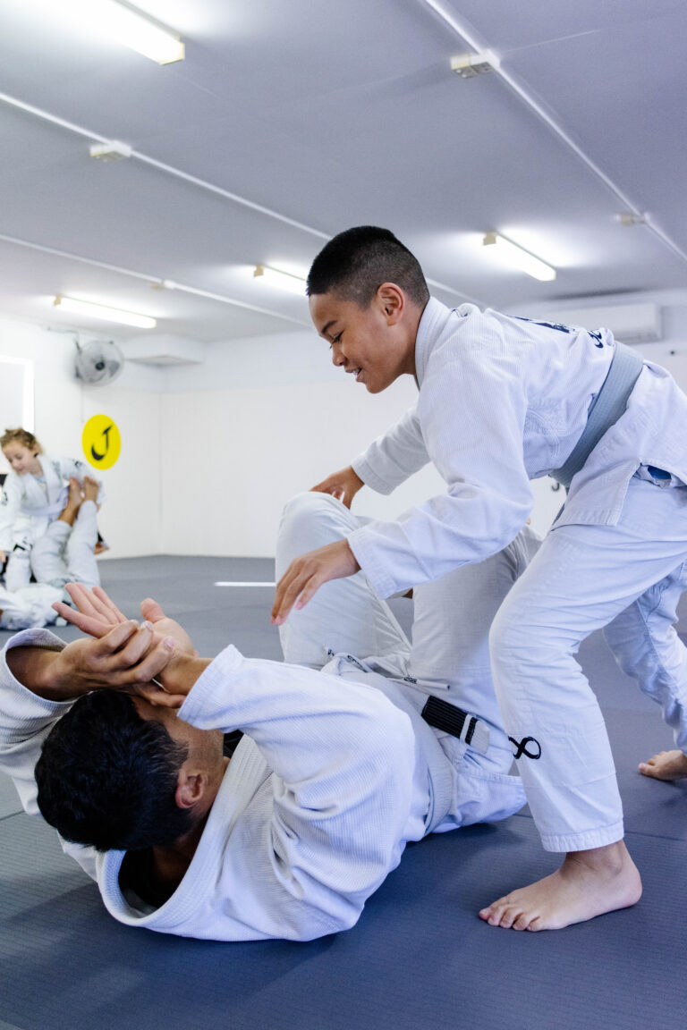 Children and parents warming up together before Brazilian Jiu-Jitsu class.